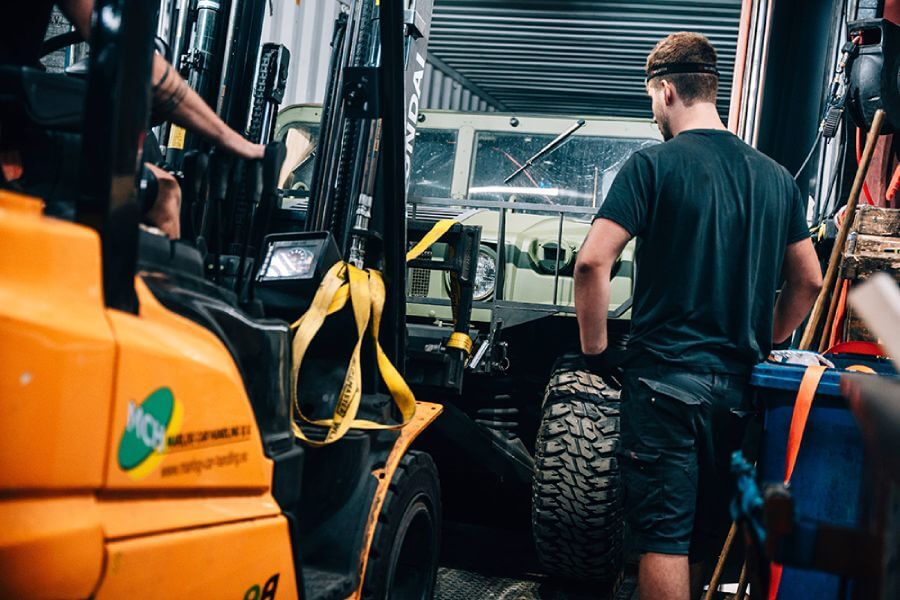 Voertuig wordt geladen voor internationaal transport bij auto-import waarbij invoerrechten en btw worden berekend